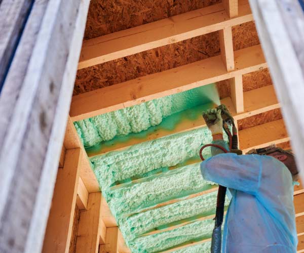 Spray foam insulation installer, insulating home's ceiling.